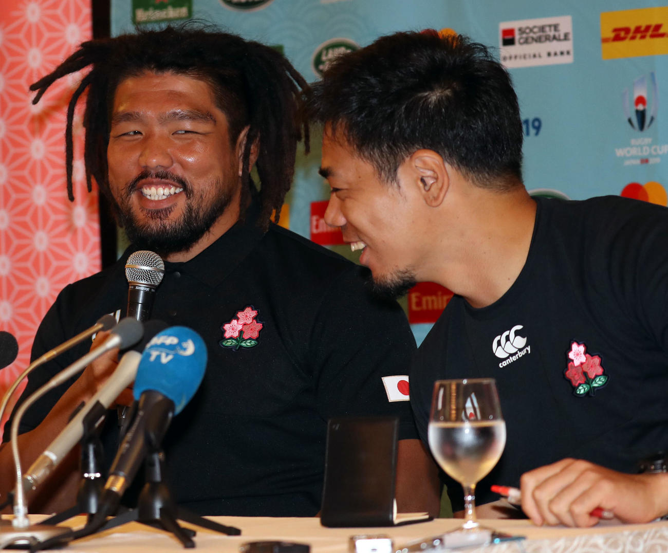 会見で佐藤通訳（右）の貢献度について質問され、照れ笑いする堀江（撮影・狩俣裕三）