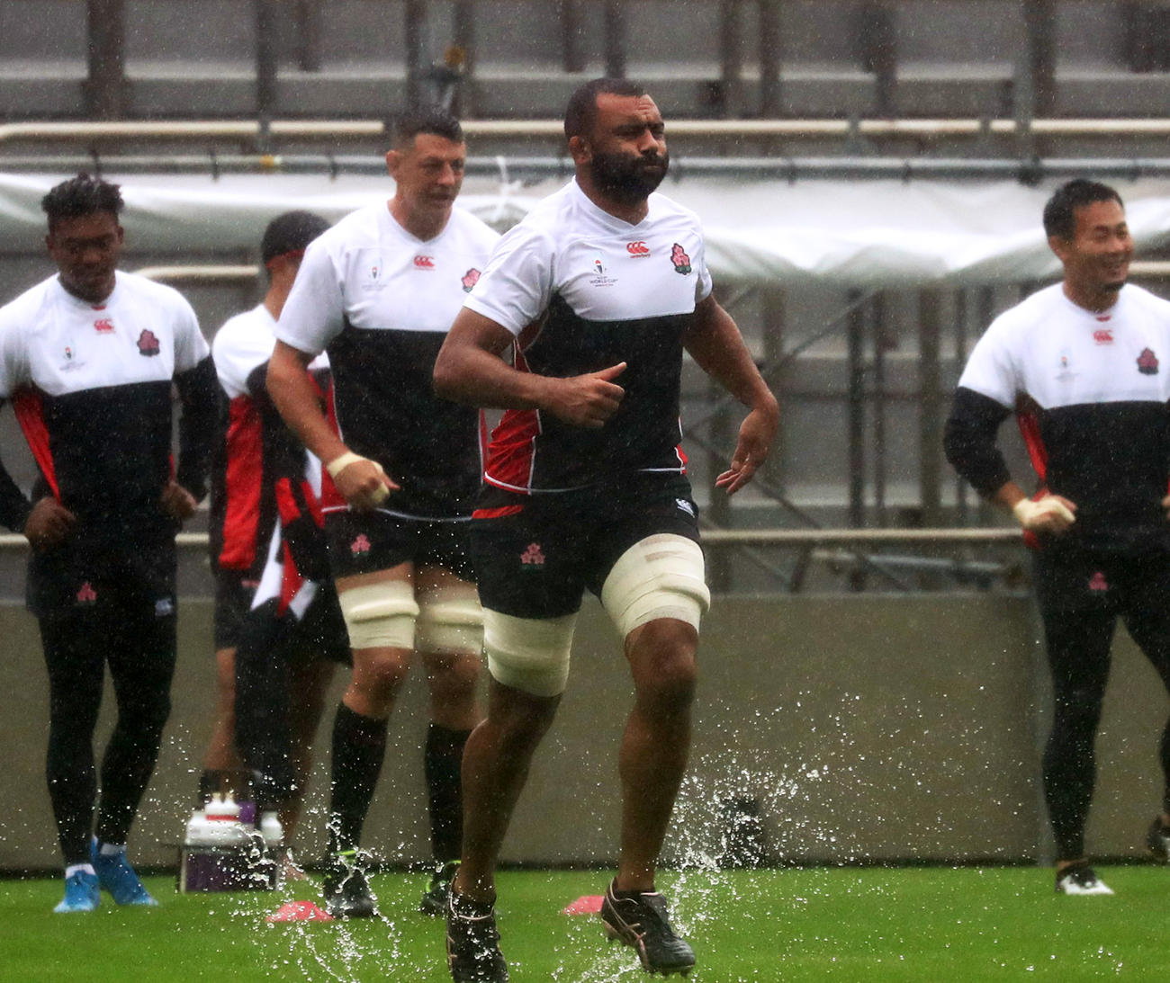 台風19号が接近する中、水しぶきを上げながらダッシュをするリーチら日本代表の選手たち（撮影・狩俣裕三）