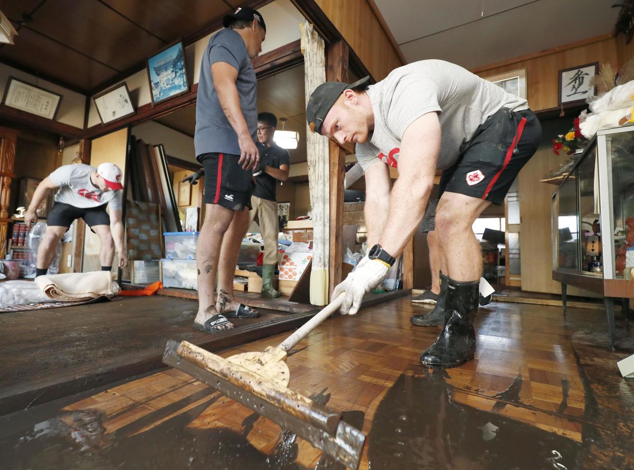 床上浸水した住宅から泥をかき出すラグビーW杯カナダ代表のピーター・ネルソン（共同）