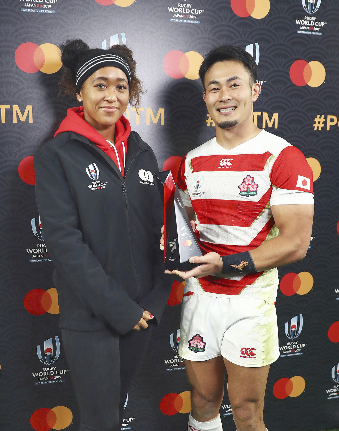最優秀選手に選ばれ、プレゼンターの大坂なおみ（左）から受け取ったトロフィーを手に笑顔の福岡（ワールドラグビー提供・ゲッティ＝共同）