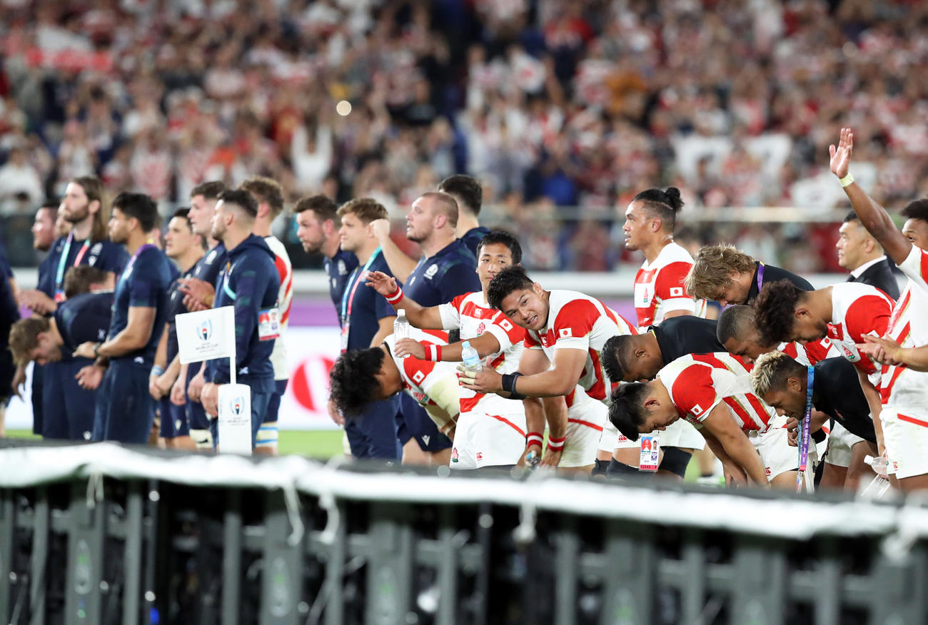 試合後、スコットランドの選手といっしょにサポーターにあいさつする日本代表の選手たち（撮影・狩俣裕三）