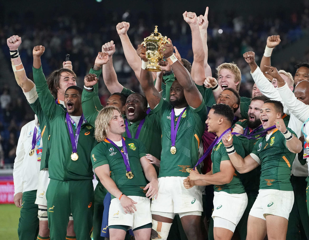 イングランド対南アフリカ　優勝し、ウェブ・エリス・カップを掲げる南アフリカ・コリシ（中央）。左下はデクラーク（撮影・鈴木みどり）