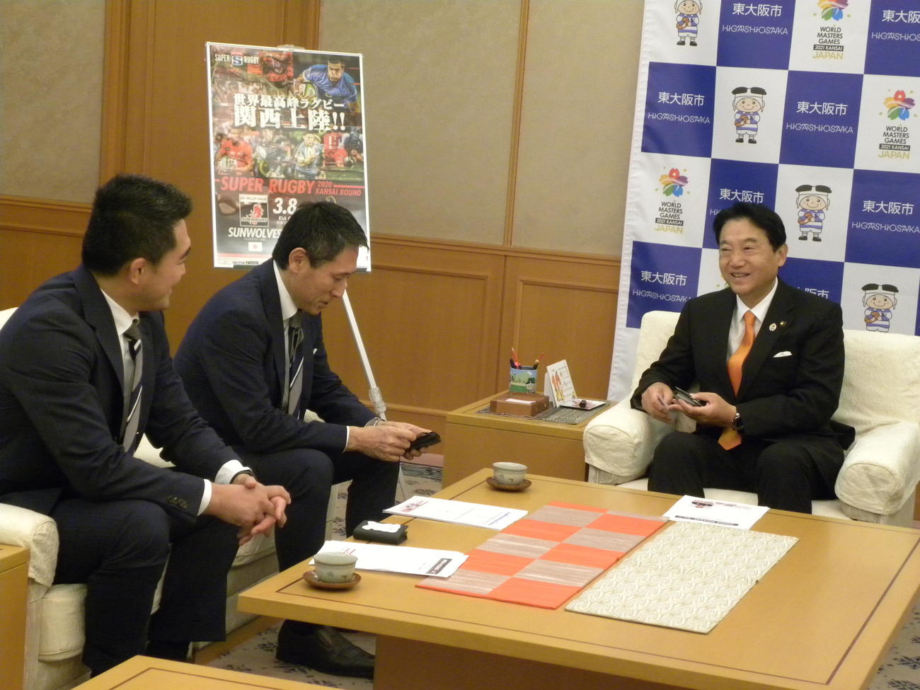 東大阪市役所を表敬訪問した左からサンウルブズの大久保直弥新ヘッドコーチ、ジャパンエスアールの渡瀬裕司CEOと野田義和市長（撮影・松本航）