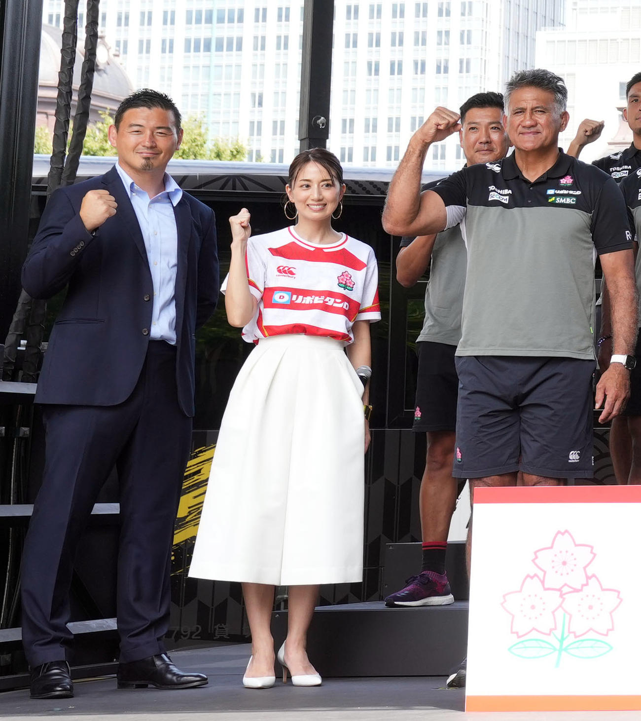 東京駅前で行われたラグビー日本代表壮行会で、ジョセフ・ヘッドコーチ（右）らと記念撮影をする応援サポーターの五郎丸氏（左）と東原亜希（撮影・狩俣裕三）