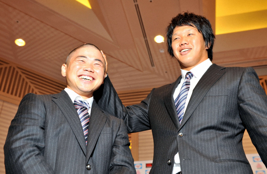 出発前会見を終えた日本代表の菊谷崇（右）が、決意の丸刈りで出席した田中史朗の頭をなでる（2011年8月29日）