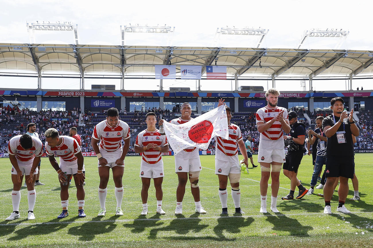 初戦でチリに勝利し、スタンドの声援に応える姫野（右端）ら日本代表の選手たち（共同）