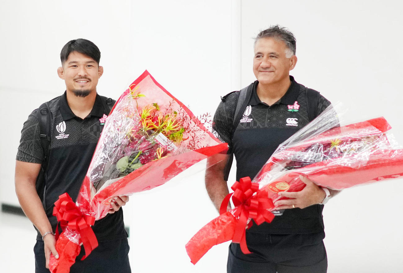 ラグビーW杯フランス大会から帰国し花束を手に笑顔を見せる姫野（左）とジェイミー・ジョセフHC（撮影・横山健太）