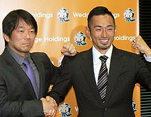 為末(右)はウェッジホールディングスの此下会長と握手を交わし笑顔