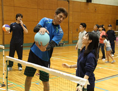 参加者にスパイクする時の手の使い方を指導する山本氏