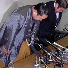 大勢の報道陣の前で、深々と頭を下げる朝青龍（左）と高砂親方