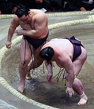 出島(右)に左手からのすくい投げを決めた朝青龍(撮影・鈴木豊)