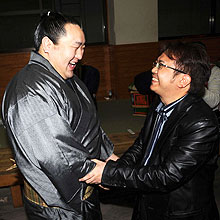 本田医師(右)と笑顔で握手を交わす朝青龍(撮影・栗山尚久)