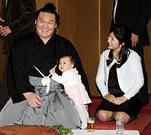長女愛美羽ちゃんから祝福され笑顔を浮かべる白鵬。右は紗代子夫人